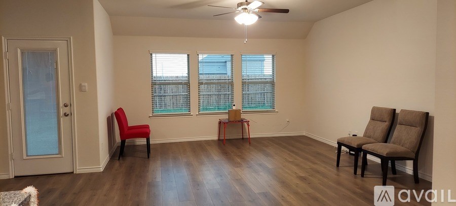 A room with a wooden floor and a ceiling fan.