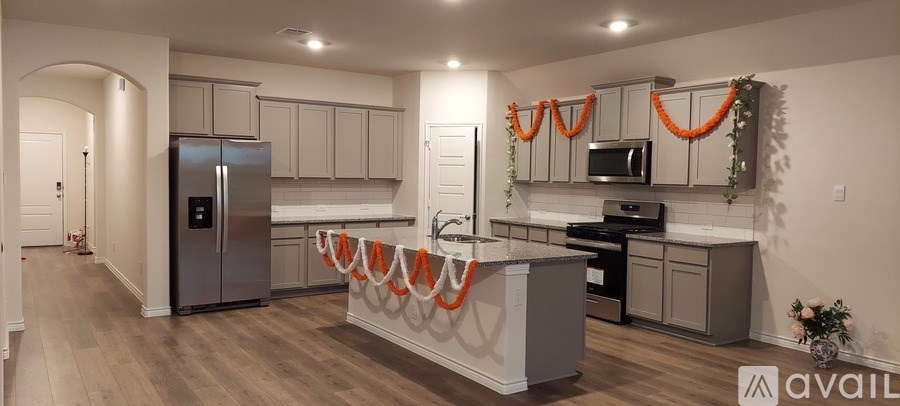 A kitchen with a refrigerator, oven, and sink.
