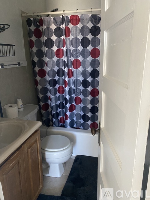 A bathroom with a toilet, sink, and shower curtain.