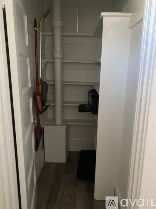 A white door with a red and black tool hanging on it.