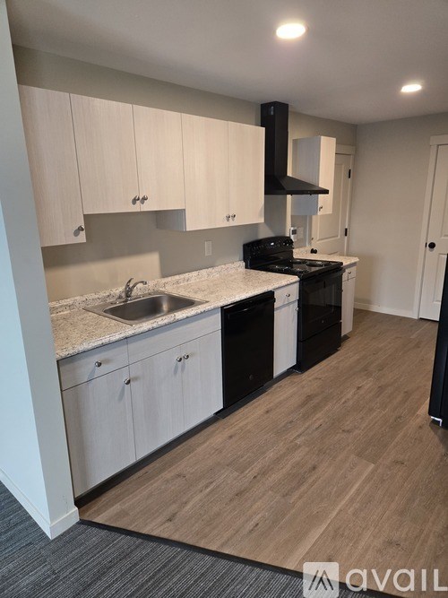 A kitchen with white cabinets and a black stove top oven.