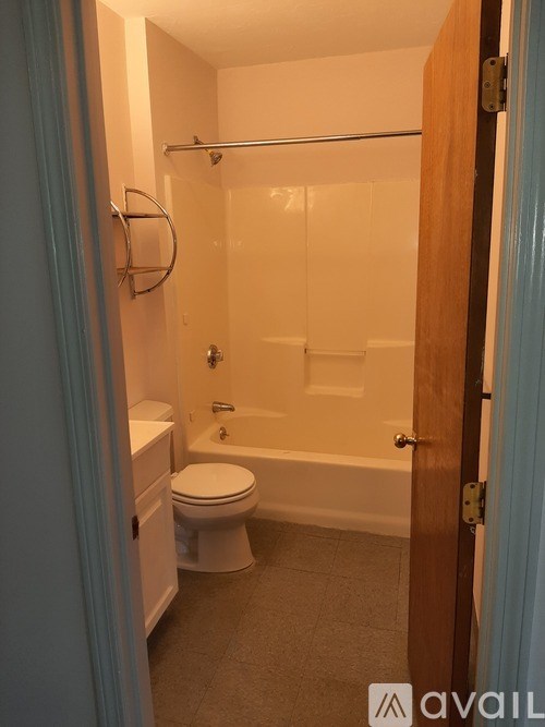 A bathroom with a toilet, tub, and towel rack.
