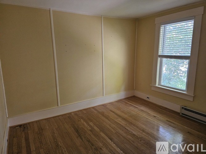 Empty room with wooden floors and a window.