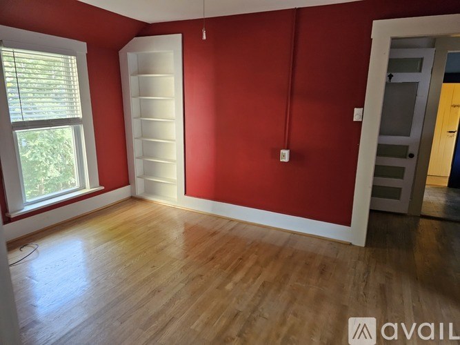 A room with red walls and wooden flooring.