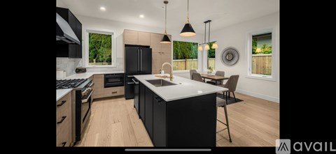 A modern kitchen with black cabinets and a large island.