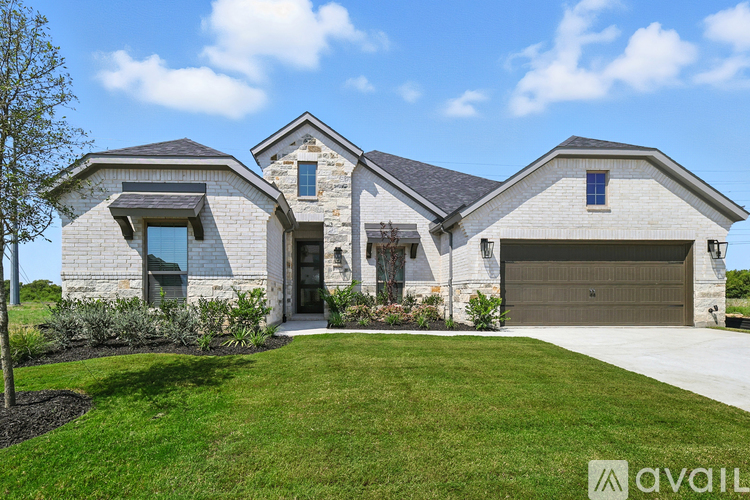 A modern house with a stone facade and a large front yard.
