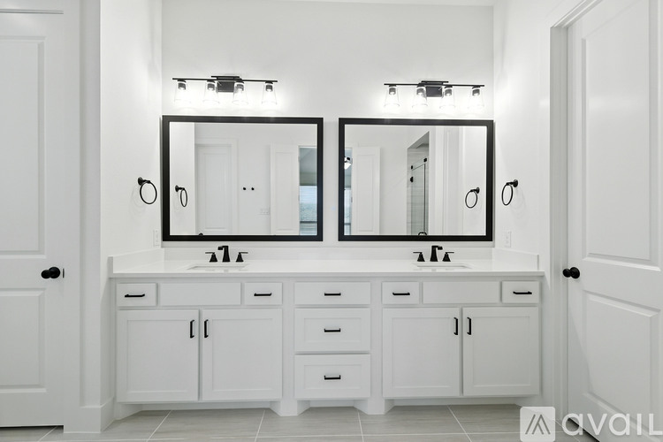 A bathroom with a white vanity and two mirrors.