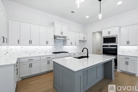 A modern kitchen with white cabinets and a central island.