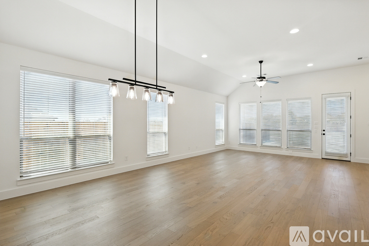 A spacious room with wooden flooring and a ceiling fan.