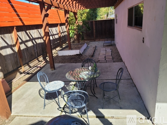 A patio with a table and chairs under a pergola.