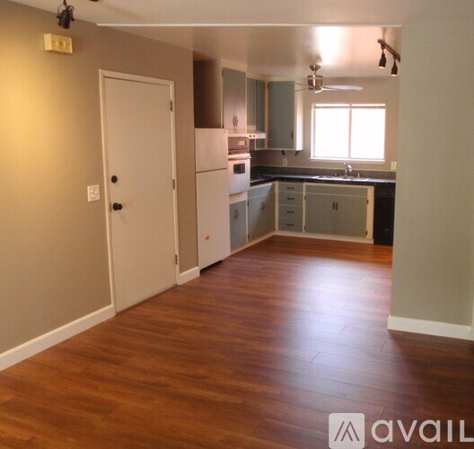 A kitchen with a white door and a window.