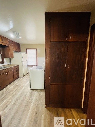A kitchen with wooden cabinets and a white fridge.