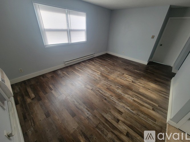 A room with wooden flooring and a window.