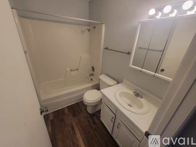 A white bathroom with a toilet, sink, and shower.