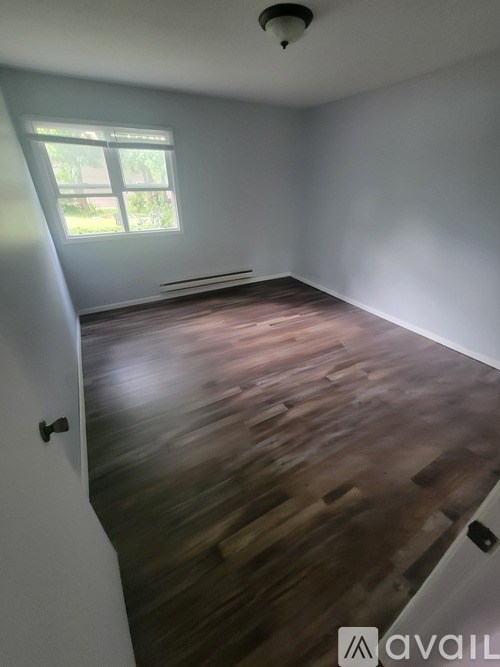 A room with wooden flooring and a window.