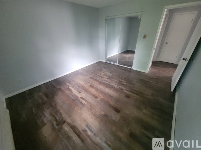 A room with wooden flooring and white walls.