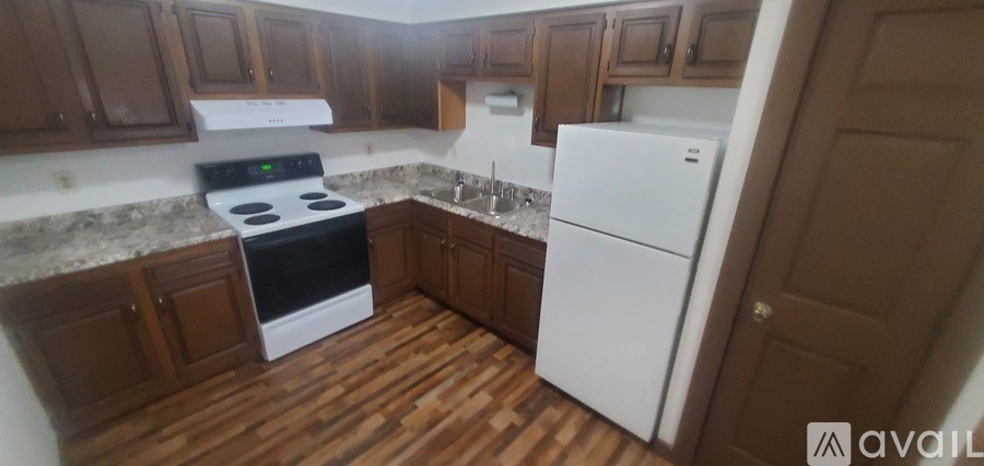 A kitchen with a white stove and refrigerator.