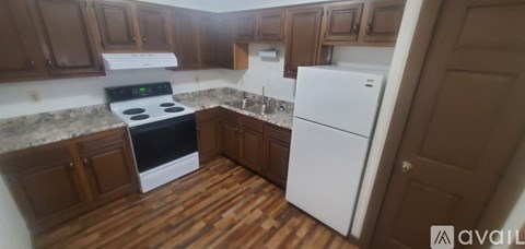 A kitchen with a white stove and refrigerator.