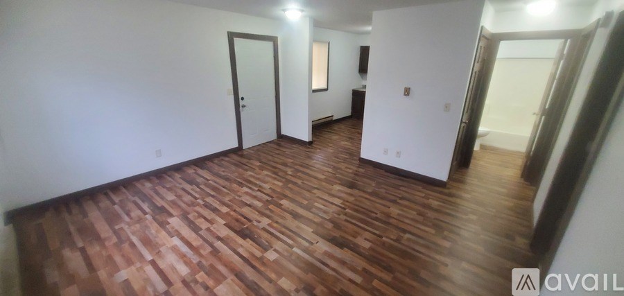 A room with wooden flooring and white walls.