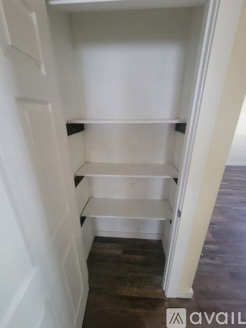 A room with wooden flooring and two doors.
