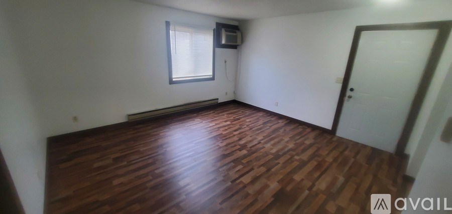 A room with wooden flooring and a window.