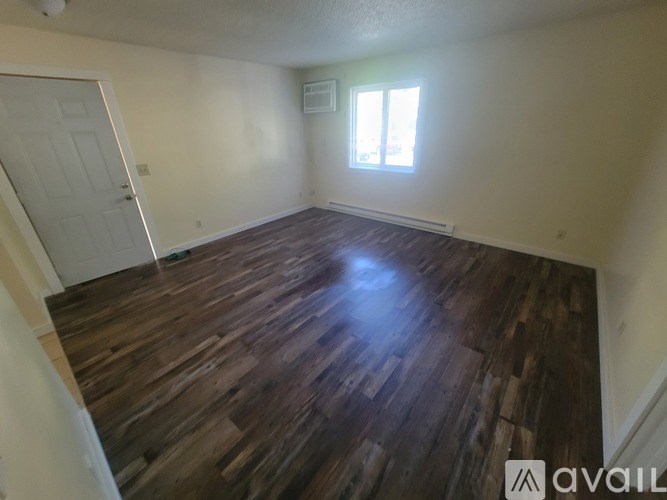 A room with a brown carpet and a white wall.