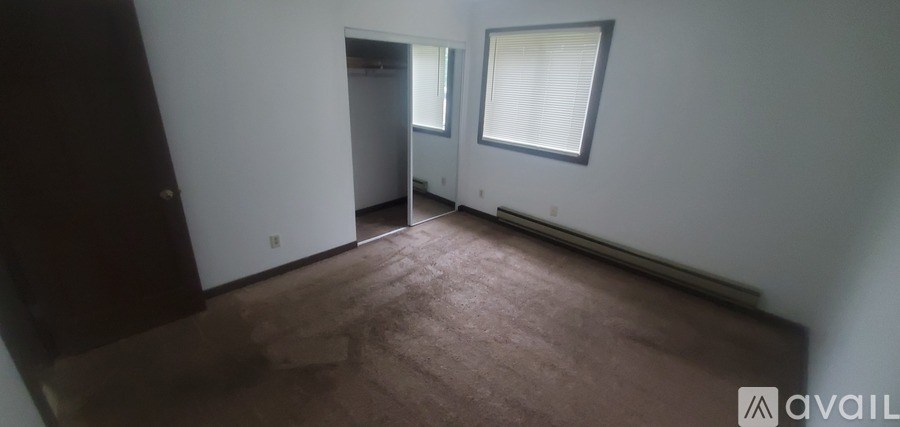 A room with brown carpet and white walls.