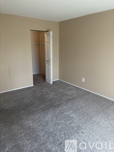 A room with a carpeted floor and a doorway leading to another room.