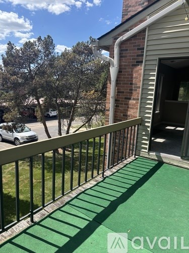 A balcony with a green floor and a metal railing.