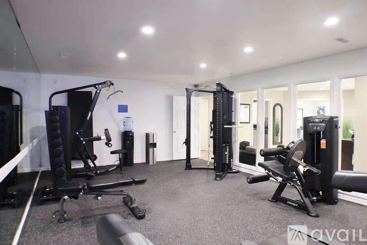 A well-lit gym with various exercise equipment.