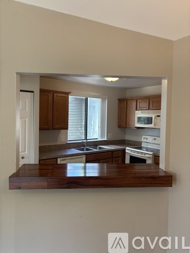 A kitchen with wooden cabinets and white appliances.