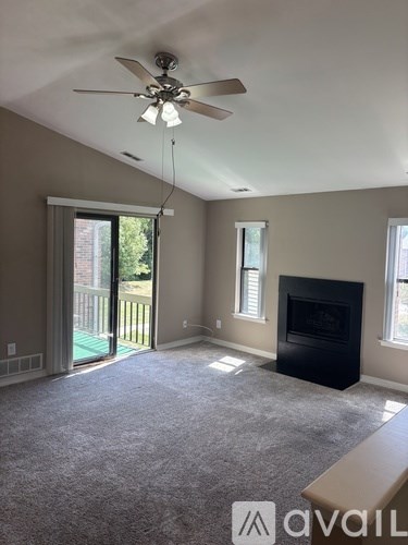 A living room with a fireplace and a ceiling fan.