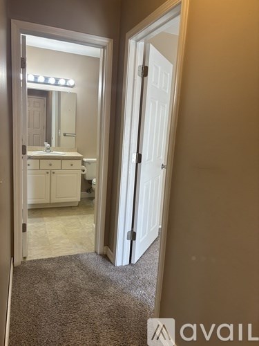 A bathroom with a sink, mirror, and lights reflected in the mirror.