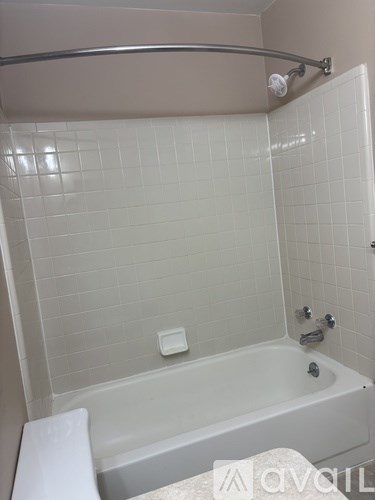 A white bathroom with a white tub and a white toilet.