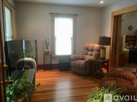 A living room with a couch, chair, and a fan.