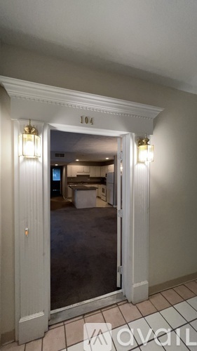 A room with a doorway leading to another room with a number 104 on the wall.