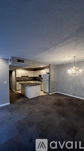 A room with a kitchen area and a dining table.
