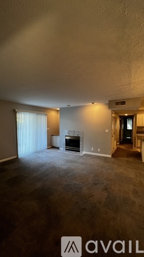A spacious living room with a fireplace and sliding glass doors.