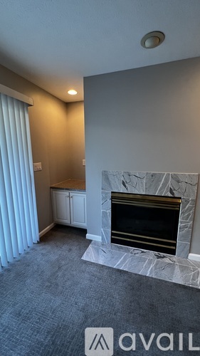 A room with a fireplace and a window with curtains.