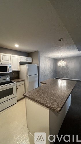 A kitchen with a granite counter top and white appliances.