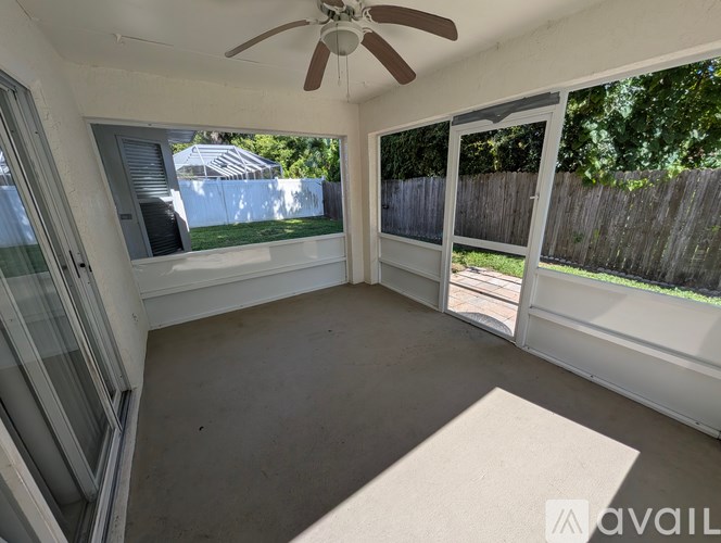A sunny patio with a ceiling fan and sliding glass doors.
