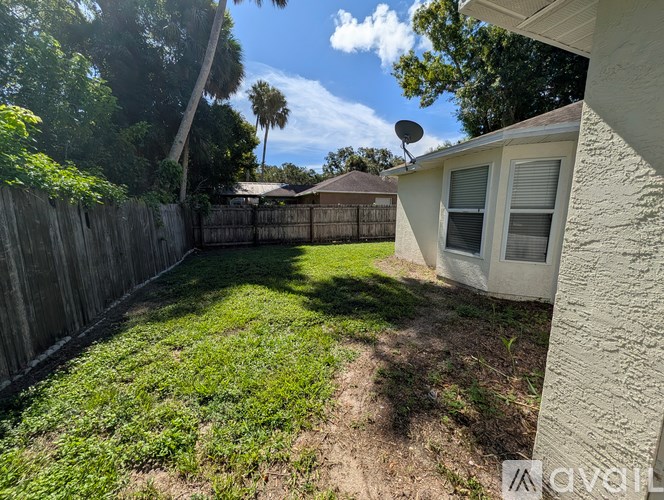 A backyard with a fence and a house.