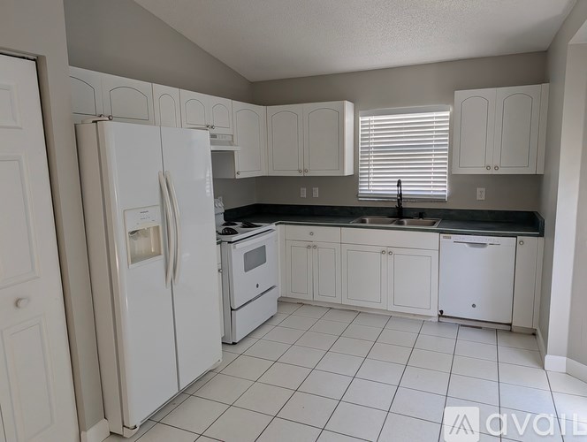 A kitchen with white appliances and cabinets.
