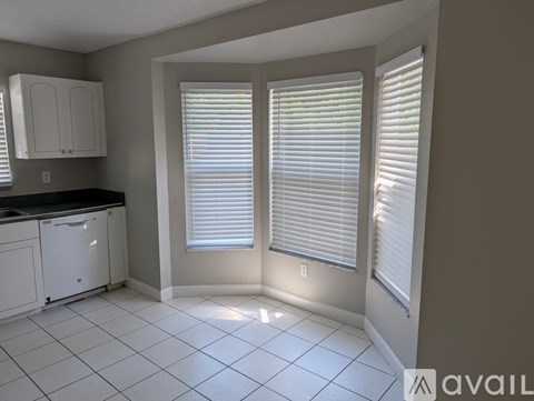 A kitchen with white cabinets and a black countertop.