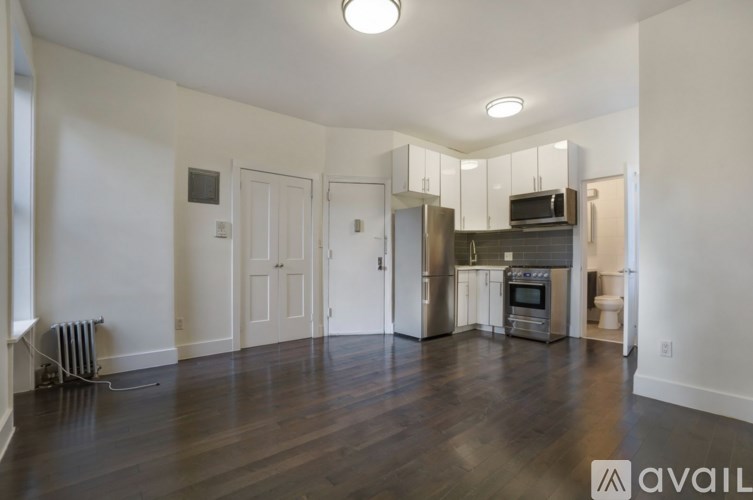 A spacious kitchen with stainless steel appliances and a wooden floor.