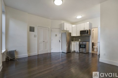 A spacious kitchen with stainless steel appliances and a wooden floor.