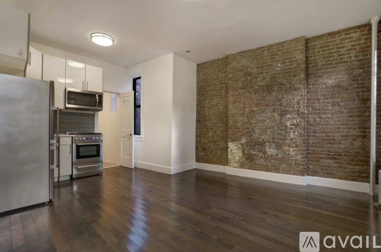 A kitchen with a refrigerator, oven, and microwave.
