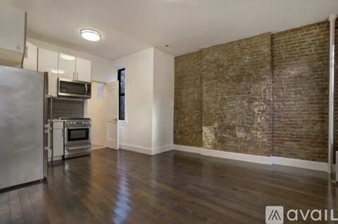 A kitchen with a refrigerator, oven, and microwave.