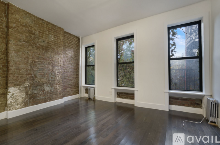 A room with a brick wall and wooden floors.