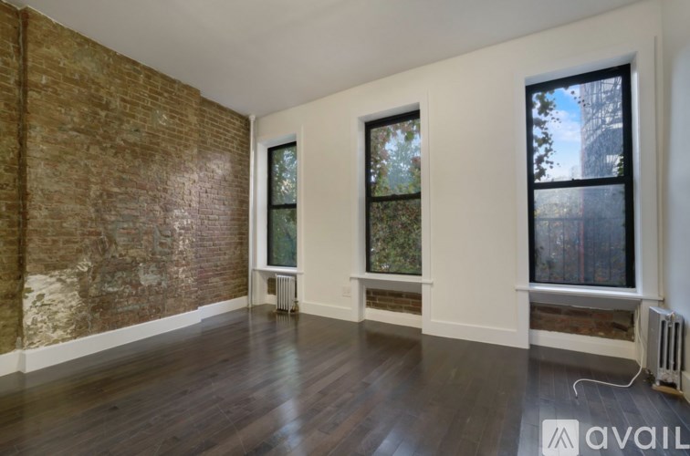 A room with a brick wall and wooden floors.